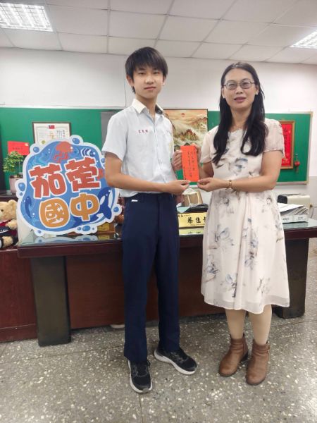國樂班學生李家緯勇奪「5A8+」頂尖成績，成為全校矚目焦點，茄萣國中校長蔡佳靜致贈獎學金。圖片/茄萣國中 提供