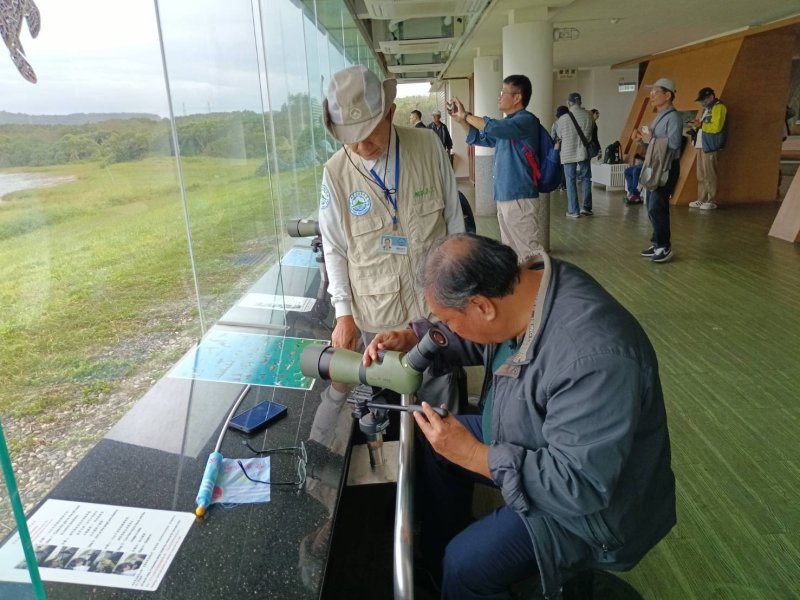 ▲在龍鑾潭遊客中心,高雄淡江校友透過高倍望遠鏡,觀察在潭面上的各種候鳥水鴨,讚嘆這座國家級濕地的生態保持的如此豐富 ▲在龍鑾潭遊客中心,高雄淡江校友透過高倍望遠鏡,觀察在潭面上的各種候鳥水鴨,讚嘆這座國家級濕地的生態保持的如此豐富